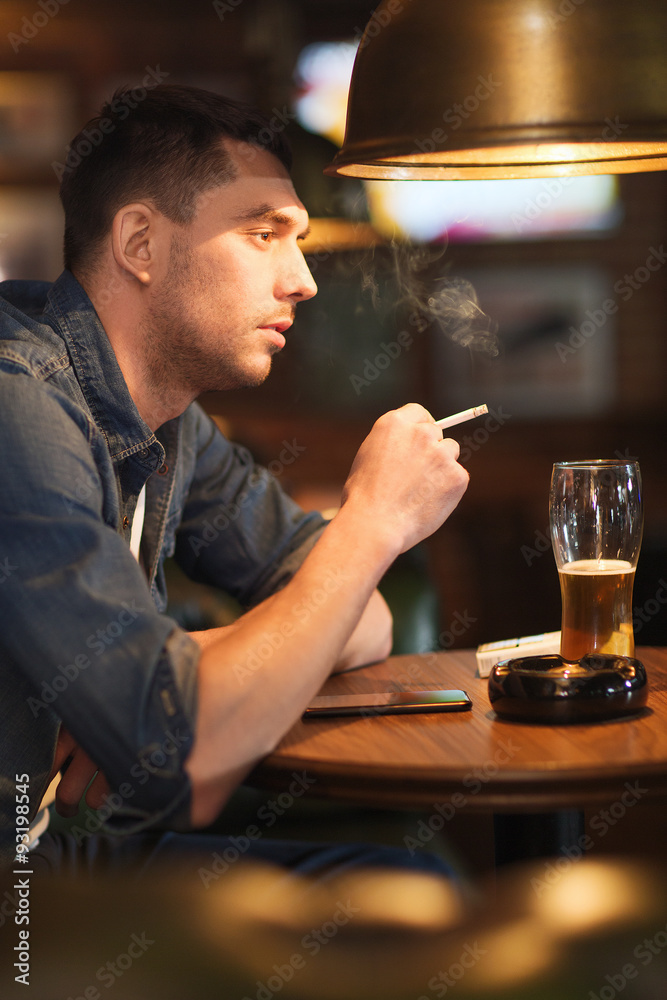 man drinking beer and smoking cigarette at bar man drinking beer and smoking cigarette at bar