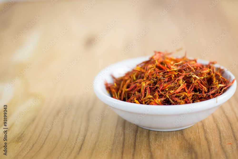 Fototapeta premium szafran w białym misce na tle drewna