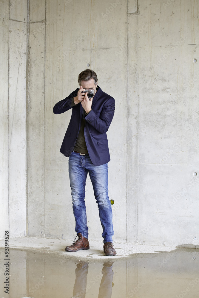 Man taking picture on construction site in unfinished building Man taking picture on construction site in unfinished building