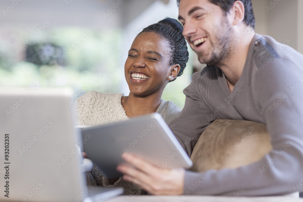 Young couple with laptop and digital tablet at home Young couple with laptop and digital tablet at home