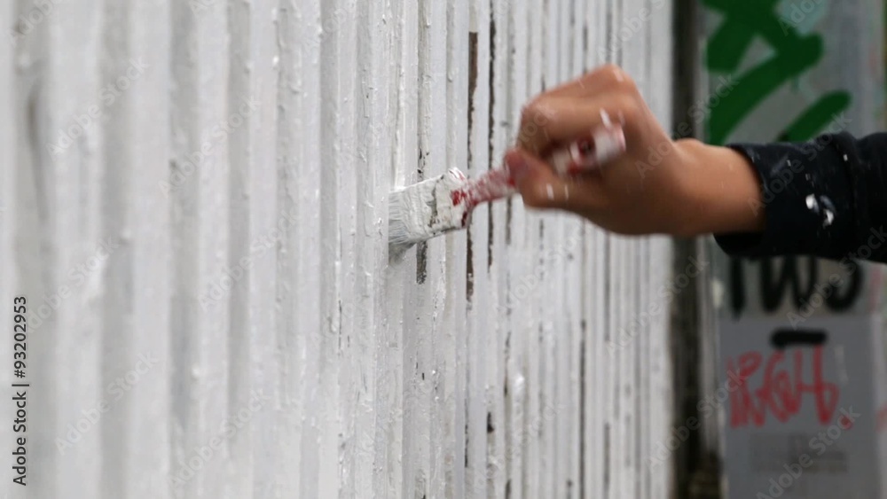 close up shot of a person painting a white picket fence close up shot of a person painting a white picket fence