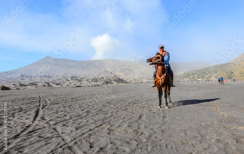 BROMO, INDONESIA - SEP 13: Unidentified worker sitting horse rental provide for tourists at Mount Bromo on SEP 13, 2015 in Java, Indonesia. Mount Bromo is one of the most visited tourist attractions
