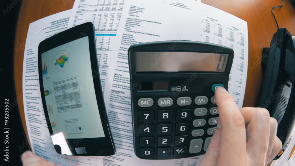 Businessman working on tablet, calculating data and calling by phone Businessman working on tablet, calculating data and calling by phone