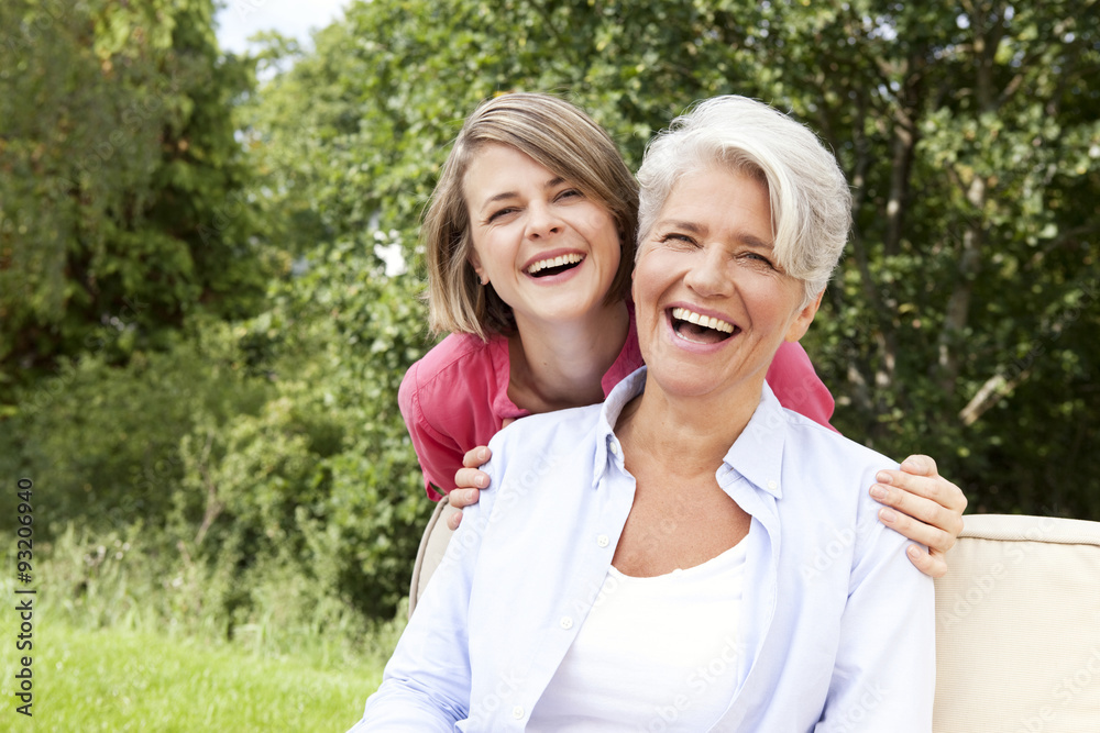 Laughing mother with adult daughter outdoors Laughing mother with adult daughter outdoors