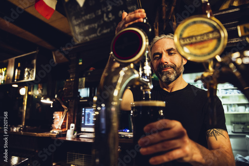 Man tapping beer in an Irish pub photo