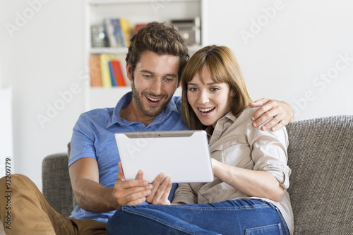 Young couple consulted their next trip on app tablet pc at home