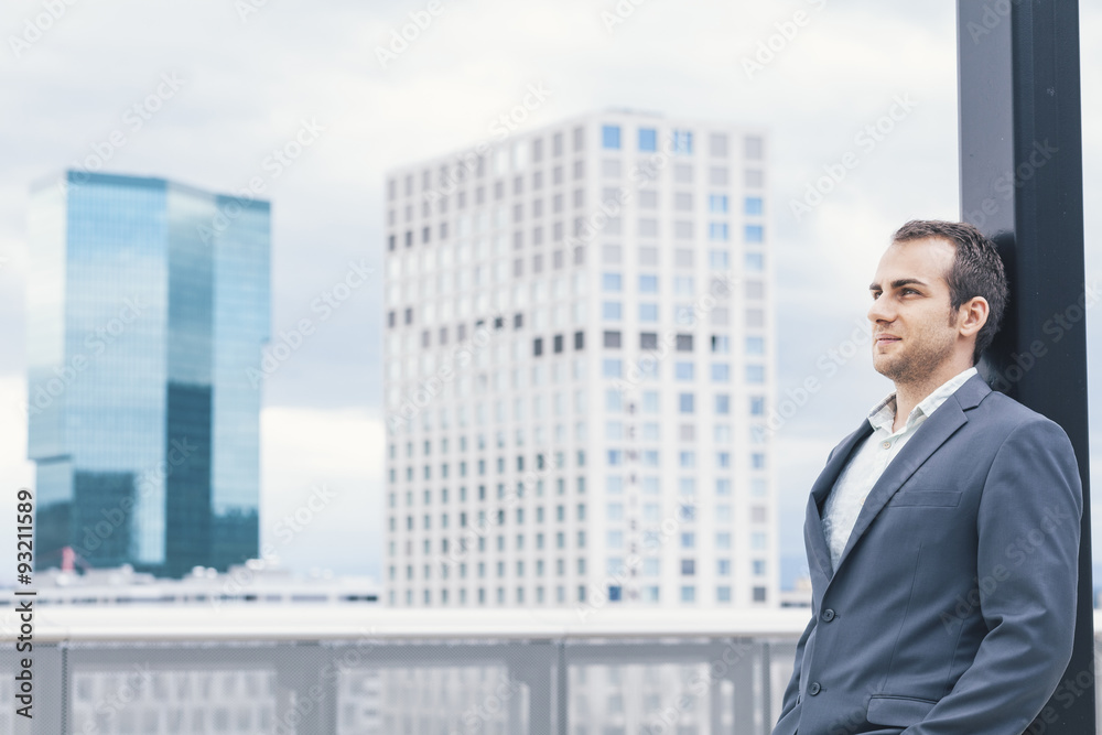 Businessman on urban balcony relaxing after busy day Businessman on urban balcony relaxing after busy day