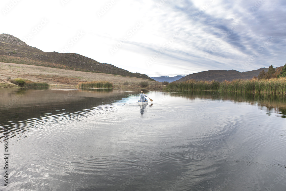 Young man paddling on a lake Young man paddling on a lake