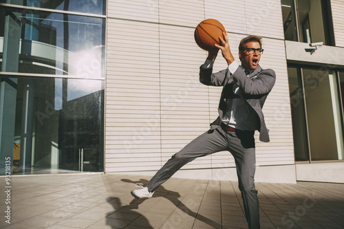 Businessman playing basketball outdoors