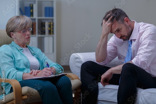 Canvas Print Troubled businessman talking with psychiatrist