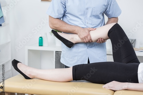 Therapist massaging womans leg