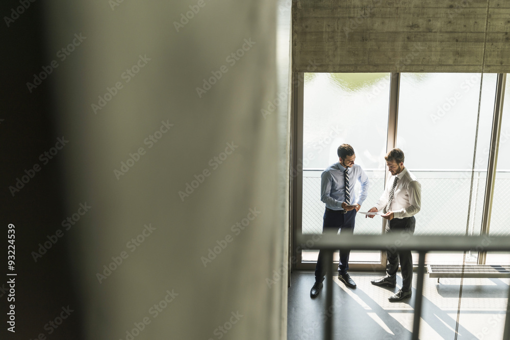 Two young businessmen discussing documents Two young businessmen discussing documents