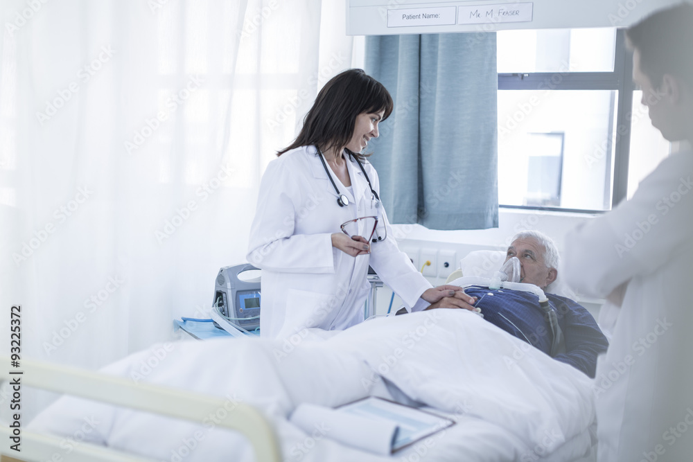 Two doctors and a patient in a hospital room Two doctors and a patient in a hospital room