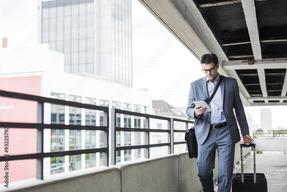 Businessman on business trip looking at his mini tablet Businessman on business trip looking at his mini tablet