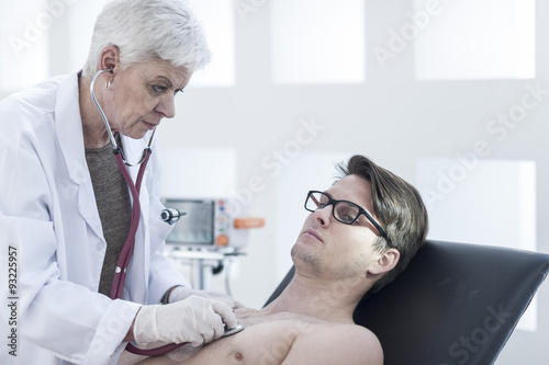 Doctor auscultating patient photo