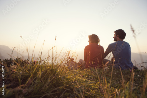 Austria, Tyrol, Unterberghorn, two hikers resting in alpine landscape at sunset