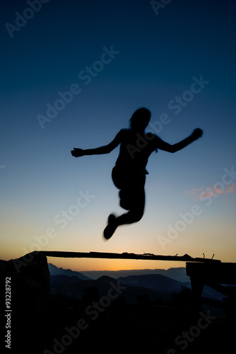 jumping over obstacles at sunset young girl day