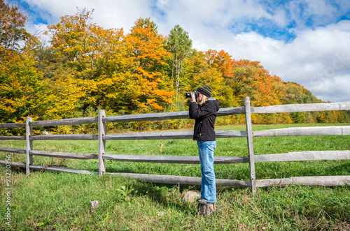 Woman taking a photograph of the fall color in the Adirondacks 
