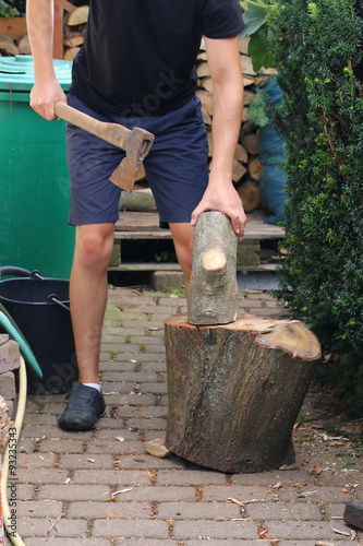 Mann hackt Holz mit alter Axt