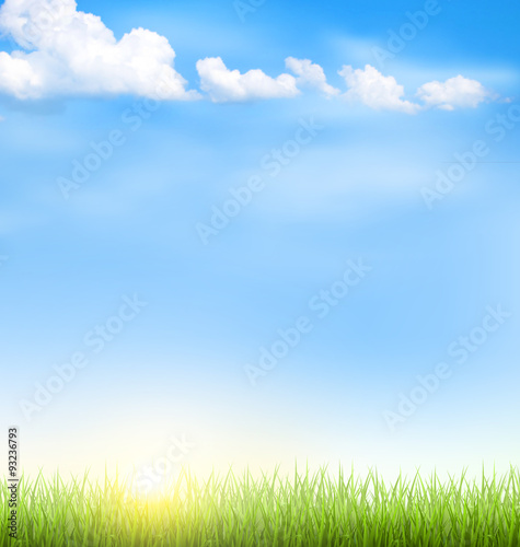 Green grass lawn with clouds and sun on blue sky