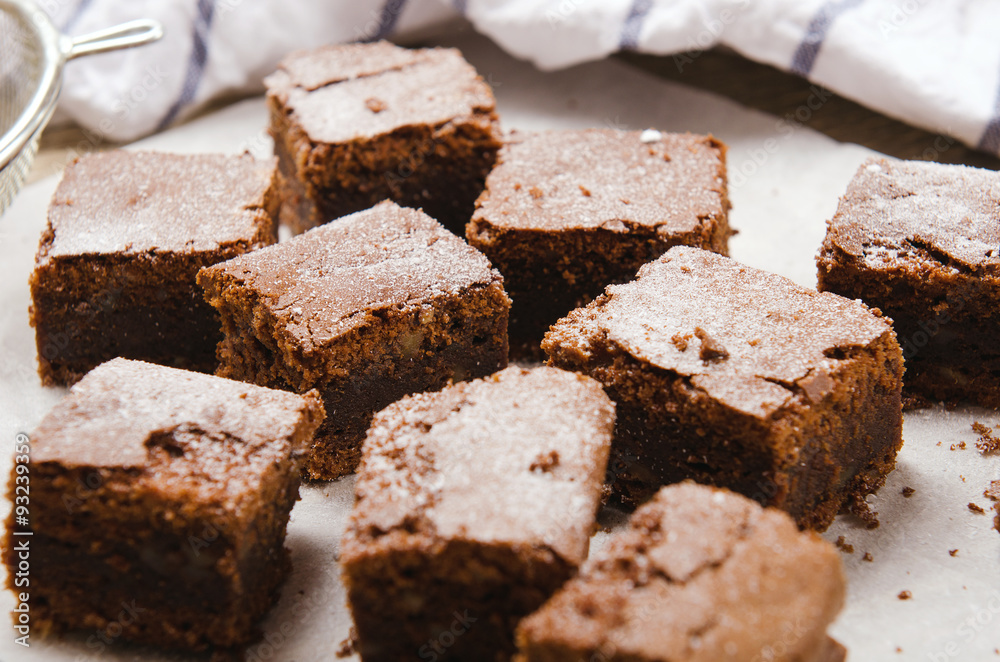 chocolate brownie diced baking paper on wooden table with a chocolate brownie diced baking paper on wooden table with a