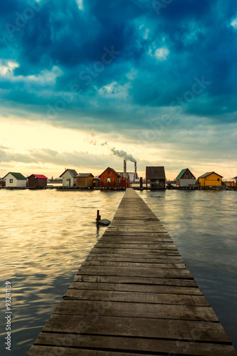 Sunset lake Bokod with pier and fishing wooden cottages photo