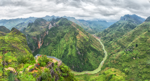 Nho Que river valley on the rocky plateau of Ha Giang followed hills covered with green grass and cloud cover make nature more majestic than