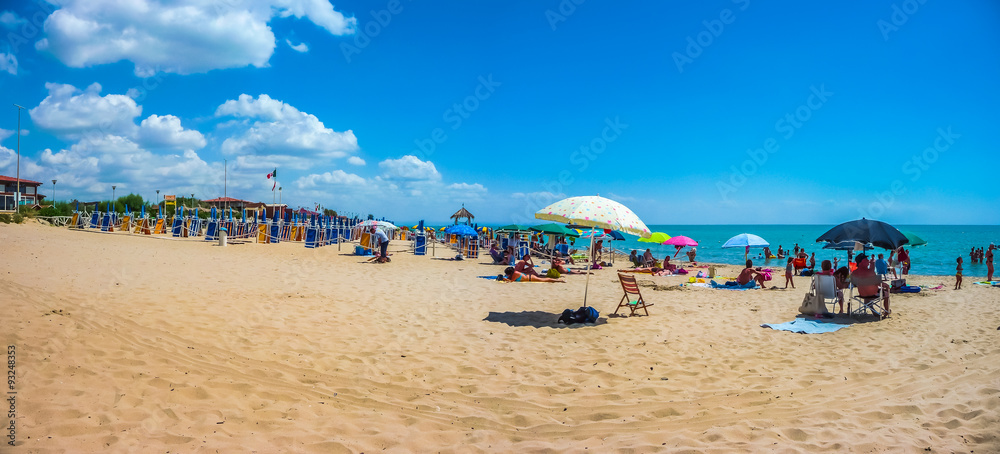 Beautiful vacation beach with beach chairs and sun shades on a sunny day at Lido di Metaponto, Basilicata, Italy