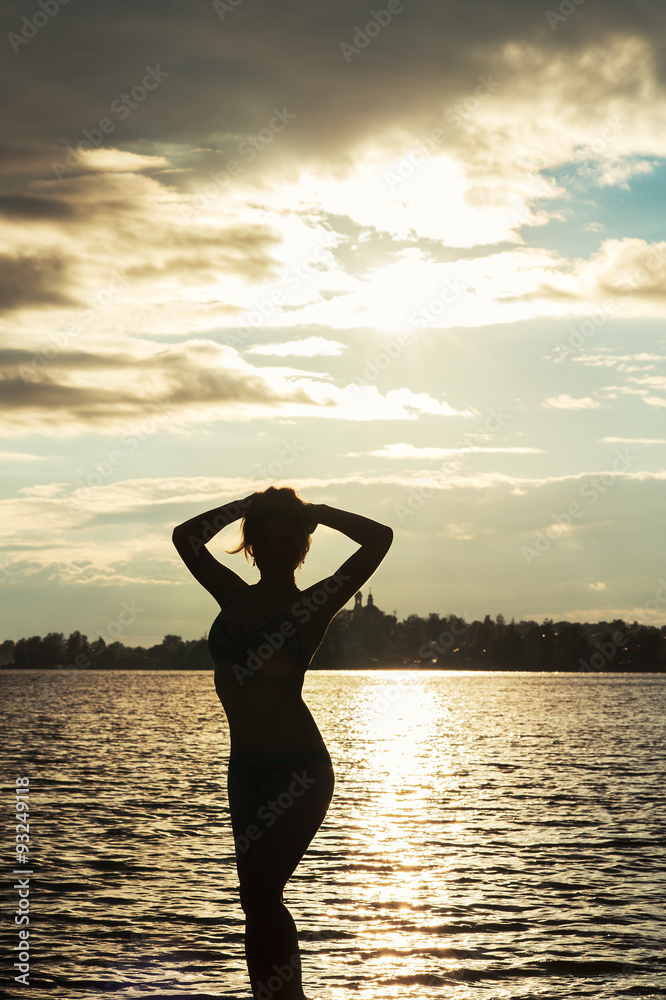 female silhouette at sunset in water