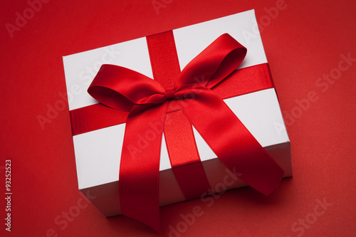 Gift with red bow on red background