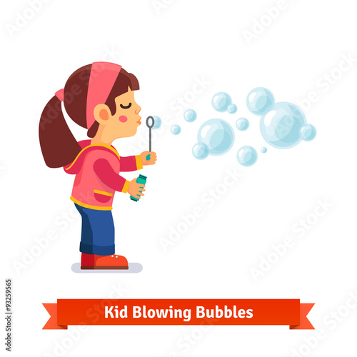Cute little girl blowing soap bubbles through wand