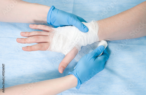 Surgeon bandaging arm