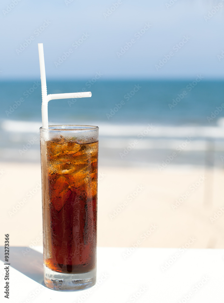 Iced soda drink in a glass on sea background Iced soda drink in a glass on sea background