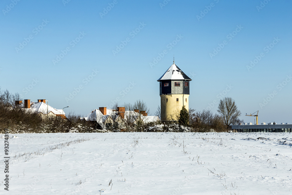 snow covered houses and old water tower in snow