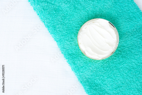 white cream  in a bowl on green textured towel background - stud