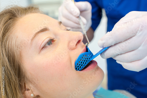Fotografie Dentist using a mouth guard on a a woman