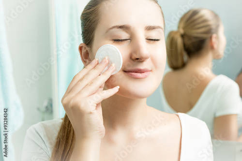 Closeup portrait of beautiful woman cleaning skin