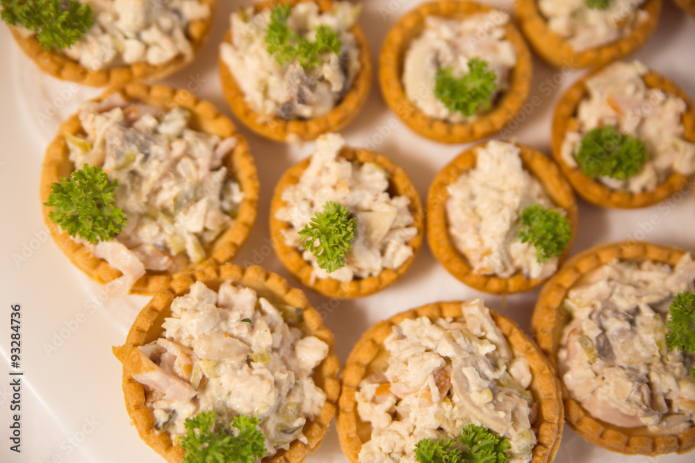 many tartlets with meat salad under mayonnaise and parsley on bu many tartlets with meat salad under mayonnaise and parsley on bu