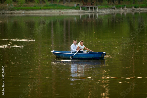 young bride and groom riding on the boat on lake