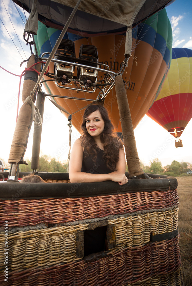 Naklejka premium Portrait of beautiful woman posing at hot air balloon basket