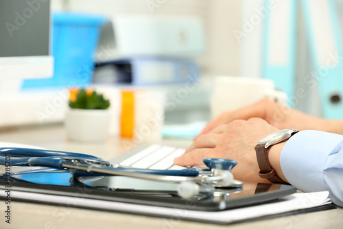 Φωτογραφία Doctor working at table in office