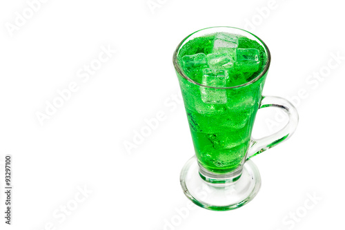 Refreshing green fizzy soft drink with ice in transparent glass