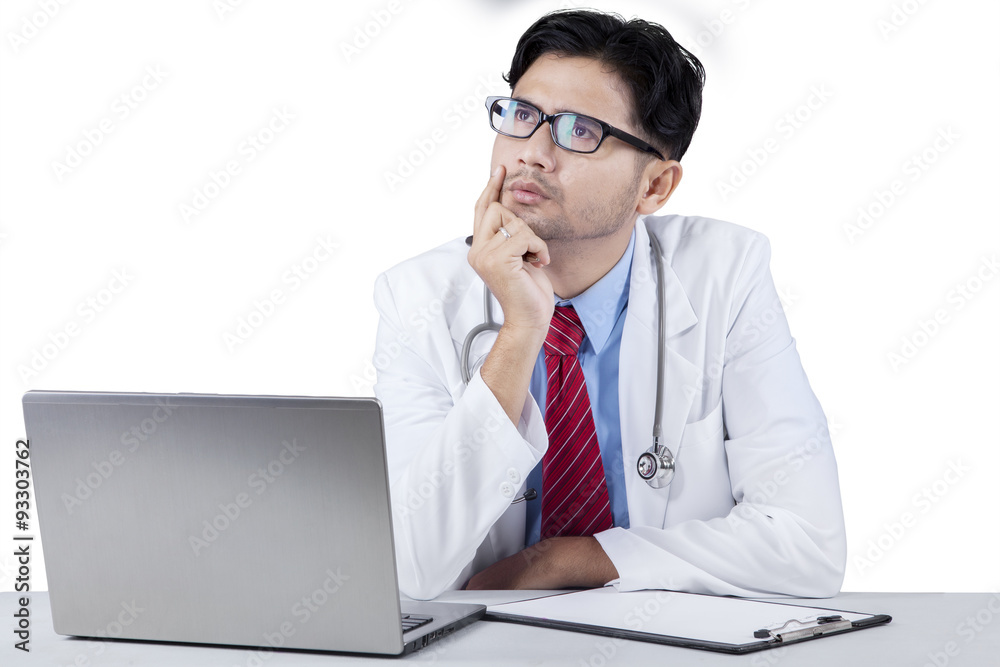 Thoughtful young doctor looking upward Thoughtful young doctor looking upward