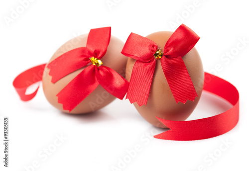 easter egg wrapped around red ribbon bow over white background