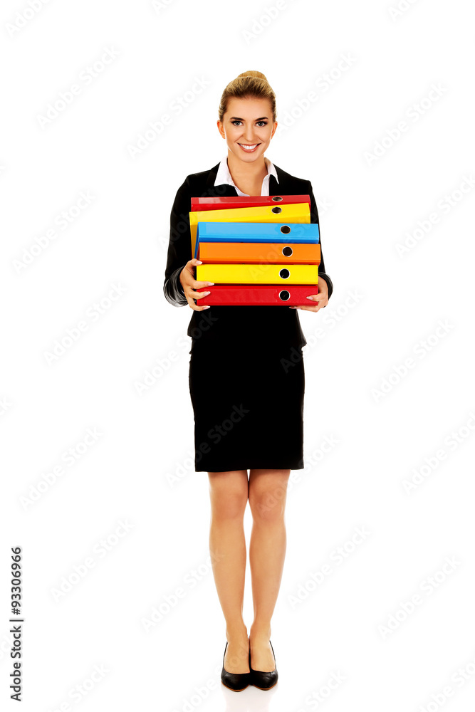 Young businesswoman carries heavy binders Young businesswoman carries heavy binders