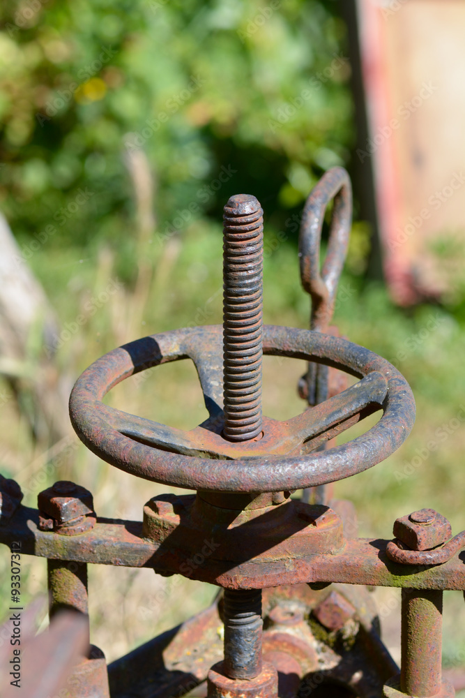 Rusty old farm machinery in garden Rusty old farm machinery in garden
