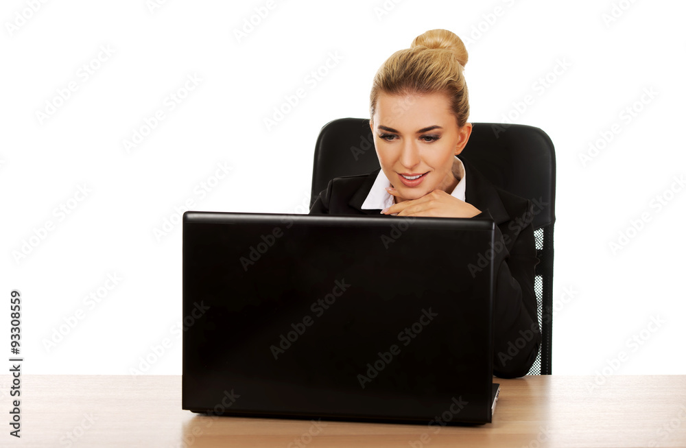 Young smile businesswoman behind the desk, using laptop Young smile businesswoman behind the desk, using laptop