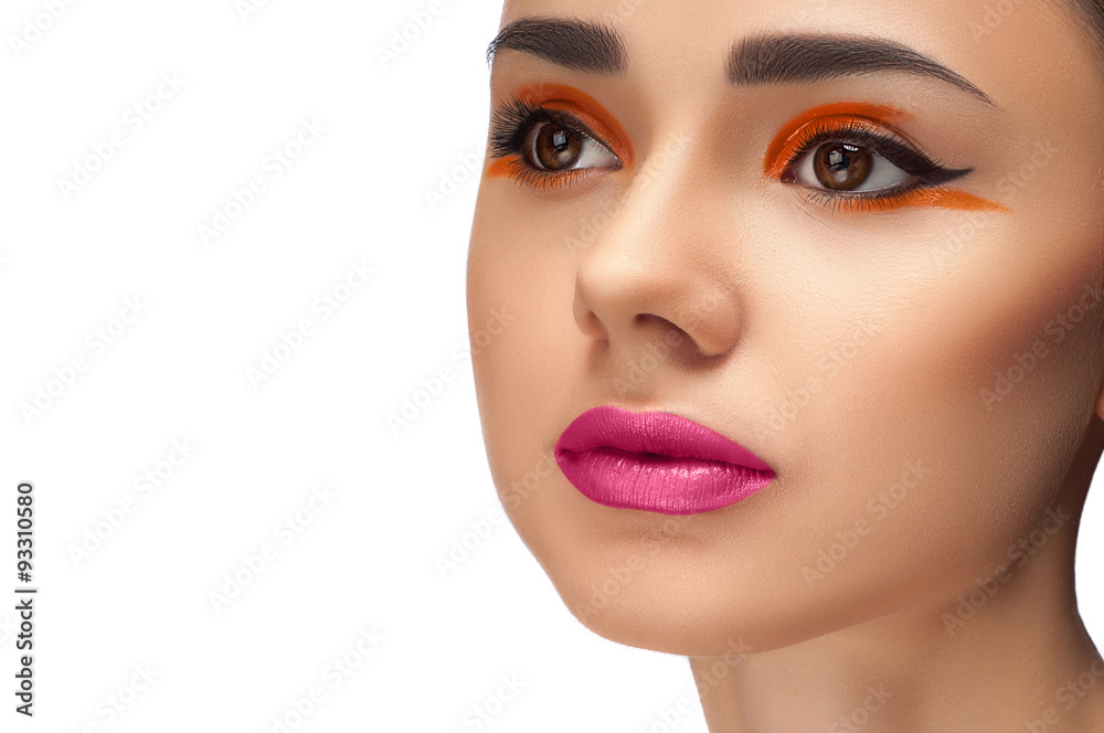 High fashion look, closeup beauty portrait of beautiful young woman model with bright makeup, perfect clean skin and colorful red pink lips and orange eyeshadow. High fashion look, closeup beauty portrait of beautiful young woman model with bright makeup, perfect clean skin and colorful red pink lips and orange eyeshadow.