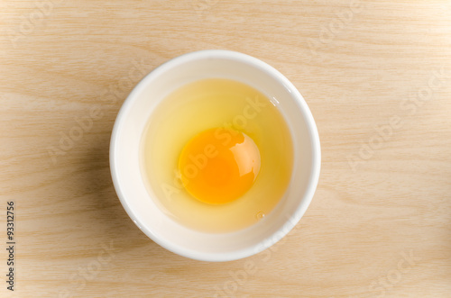 Fresh egg yolk in the bowl on wooden background,food ingredient