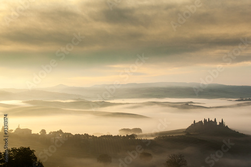 The fairytale foggy landscape of Tuscan fields at sunrise